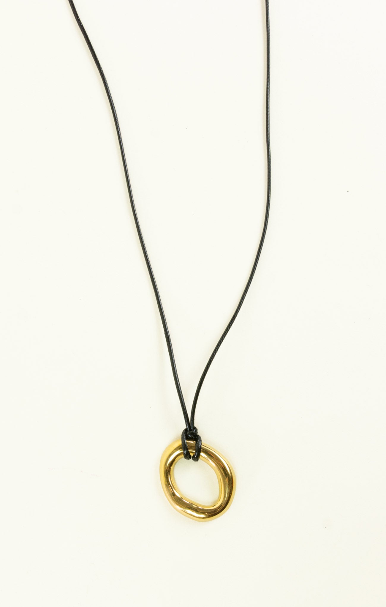 Gold necklace with a black cord on a white background