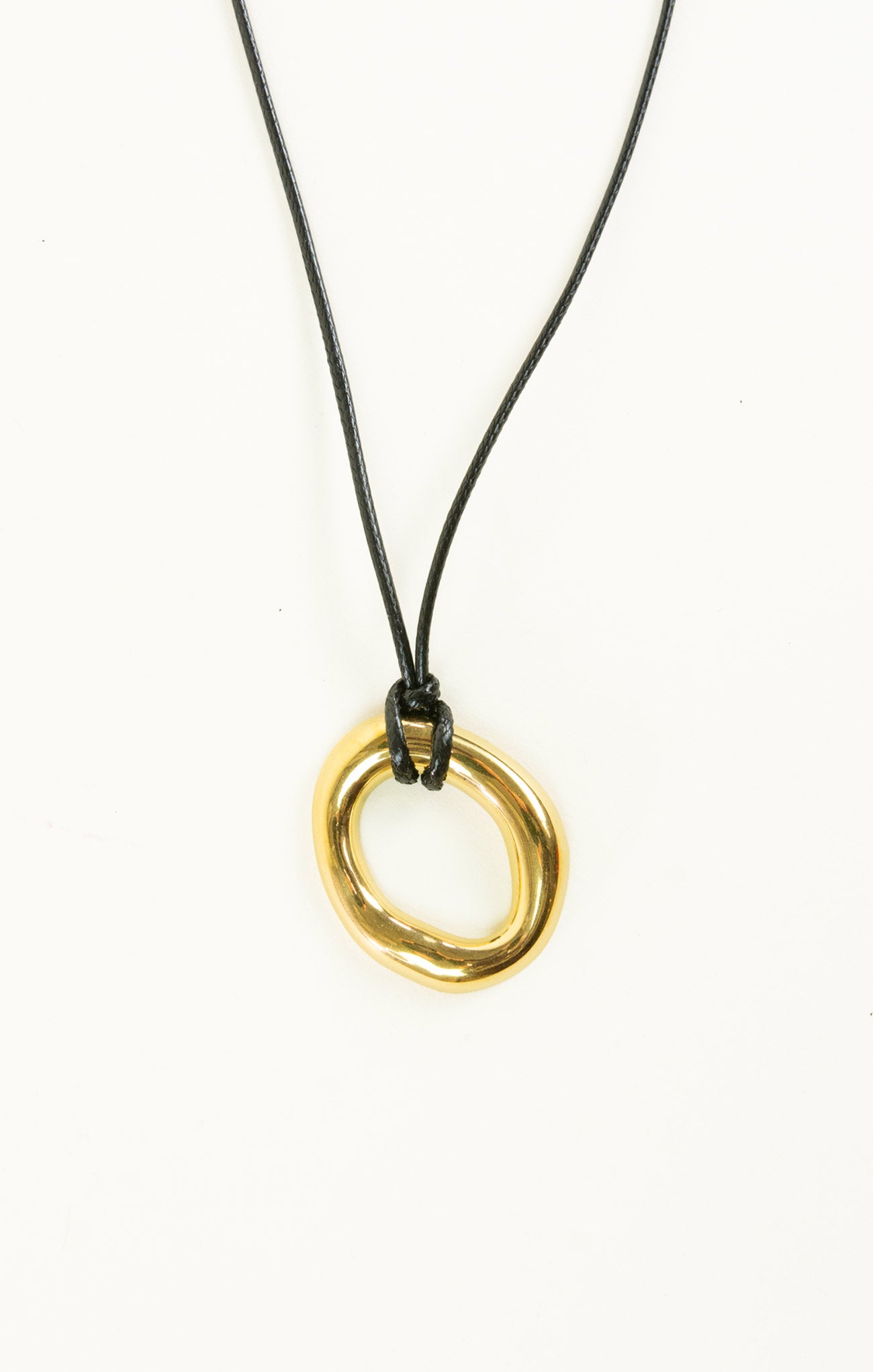 Gold circular pendant on a black cord against a white background