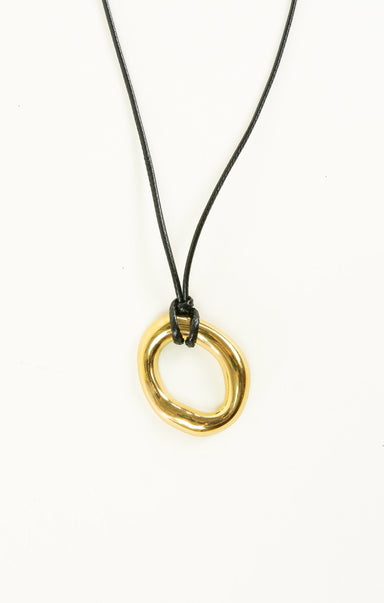 Gold circular pendant on a black cord against a white background