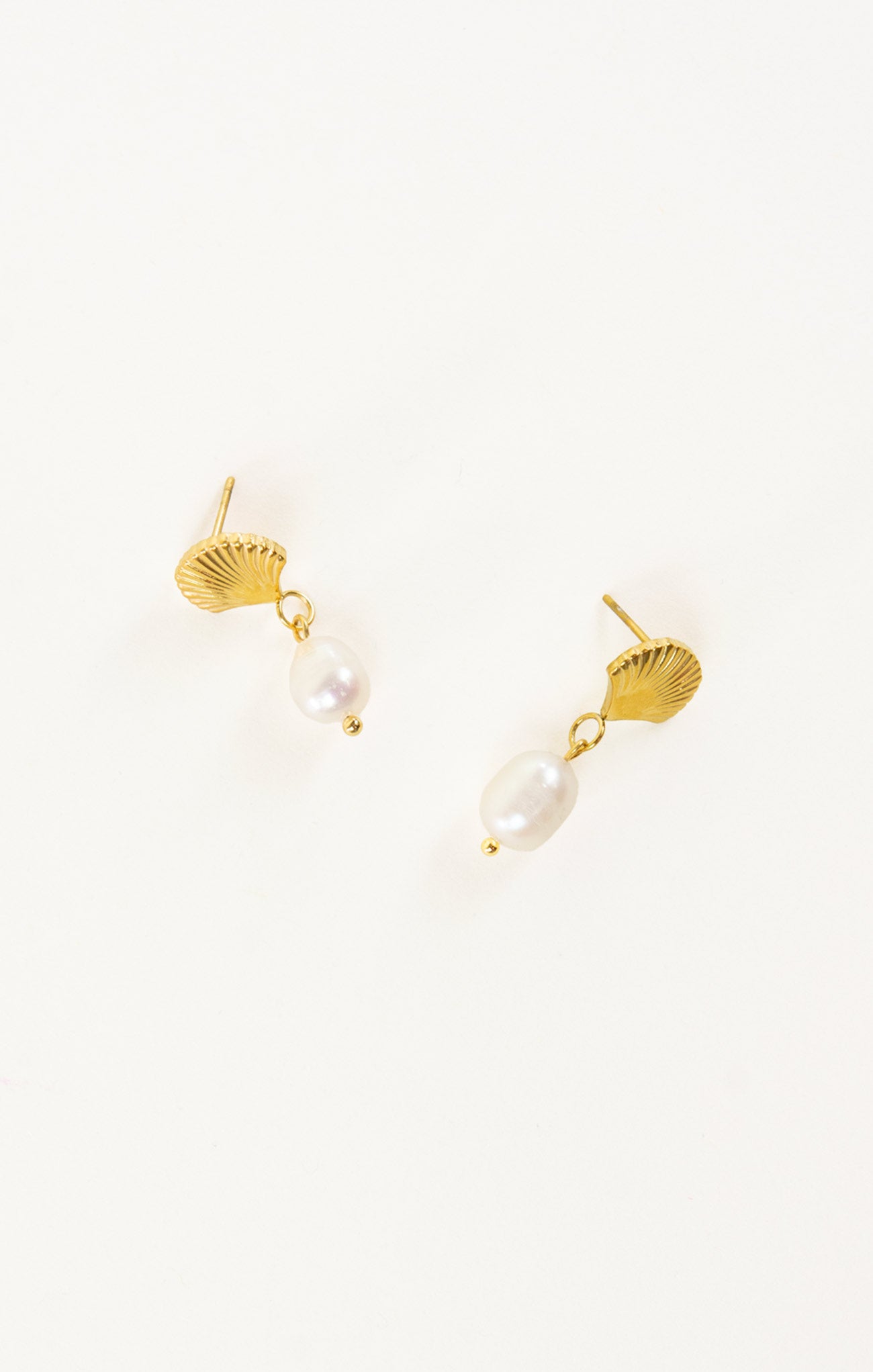 Gold earrings with pearl drops on a white background