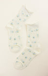 Pair of white socks with small blue floral patterns on a light beige background