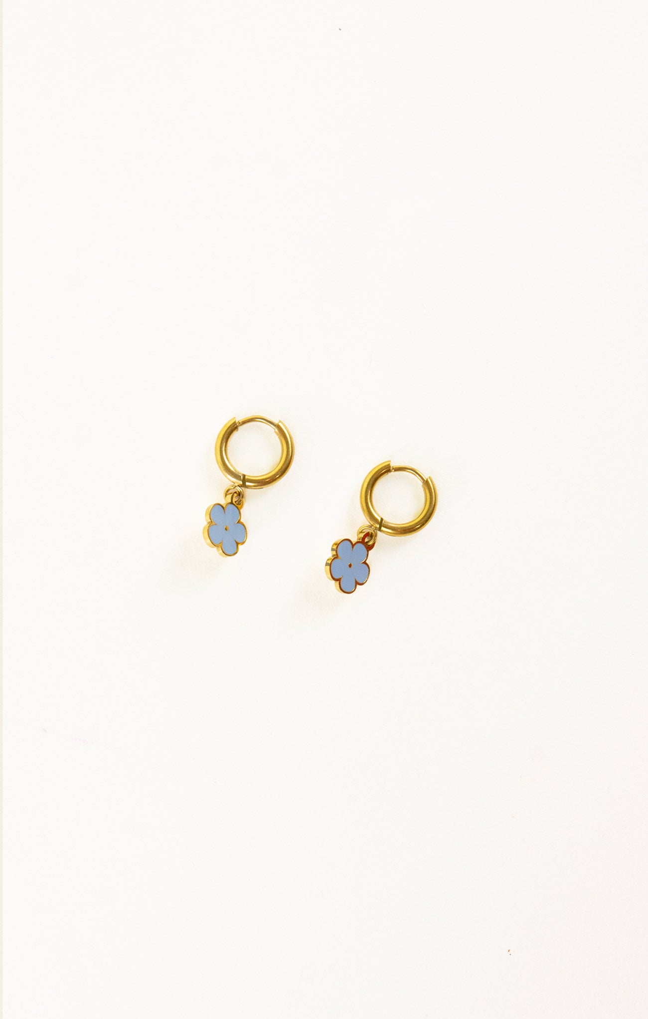 Gold earrings with blue flower-shaped charms on a white background