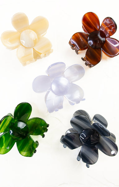 Set of five flower-shaped hair clips in different colors on a white background
