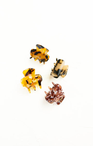 Set of four tortoiseshell hair clips on a white background
