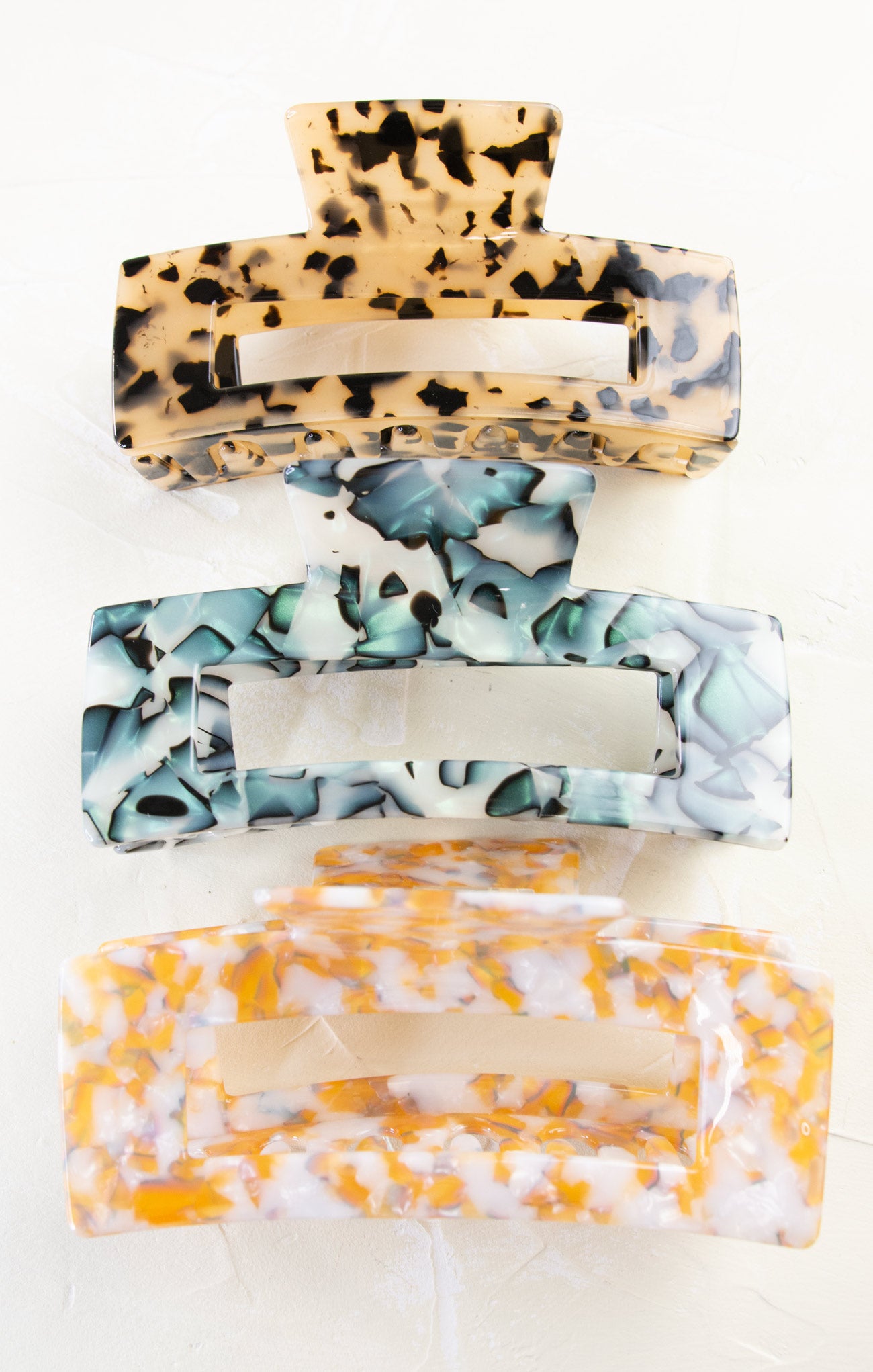 Three patterned hair clips stacked on a white background