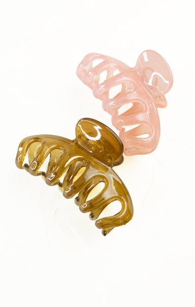 Two hair clamps, one brown and one pink, on a white background